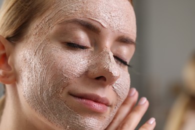 Woman with face mask on blurred background, closeup and space for text. Spa treatments