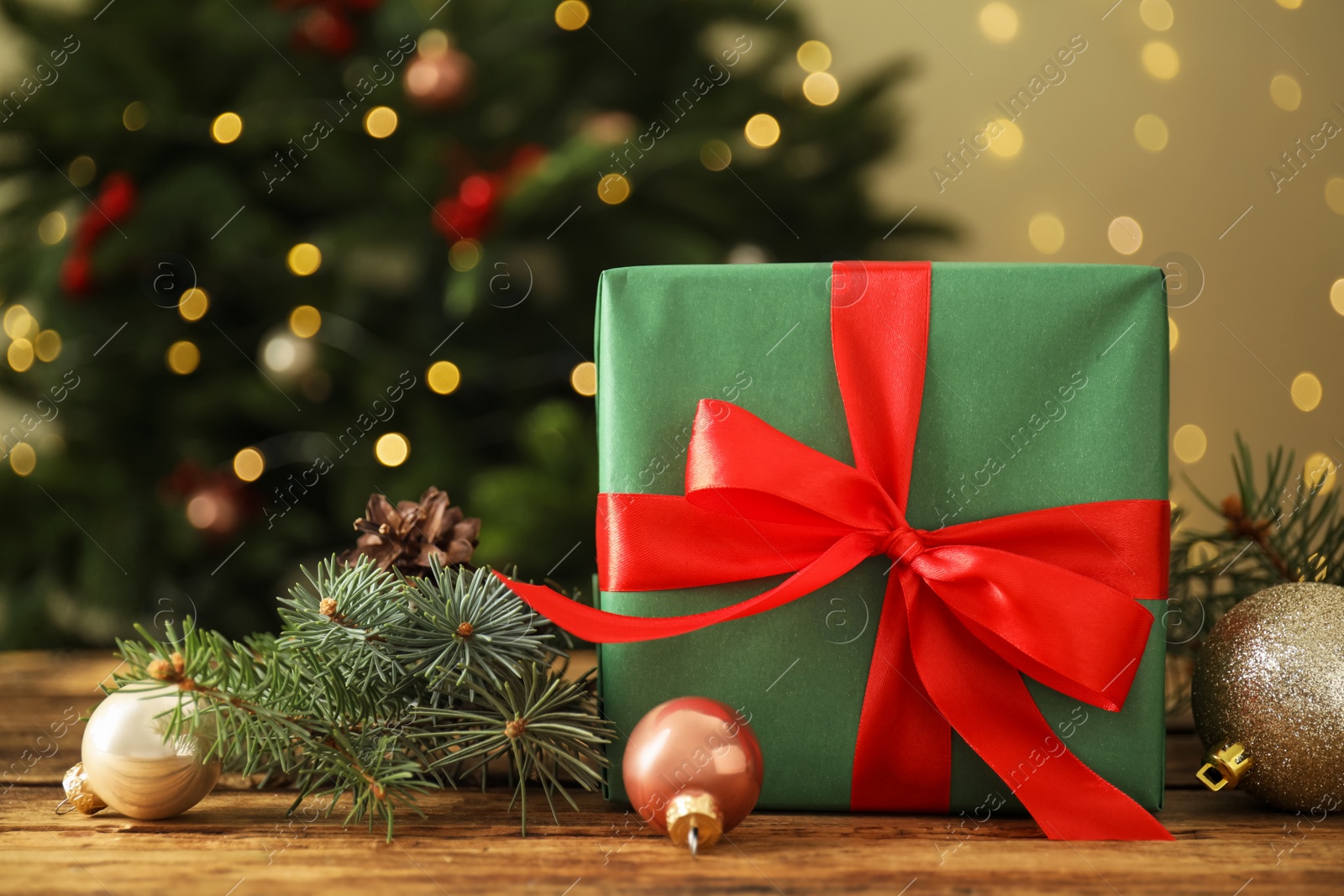 Photo of Beautiful gift box and Christmas decor on wooden table, closeup