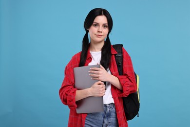 Photo of Student with laptop on light blue background