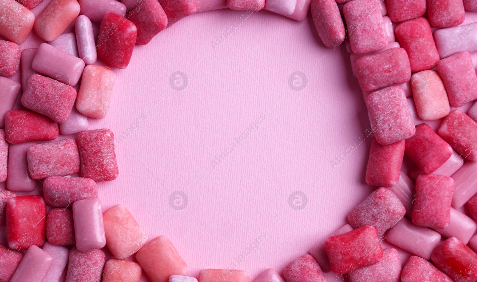 Photo of Many sweet chewing gums on pink background, flat lay. Space for text