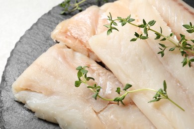 Pieces of raw cod fish and microgreens on table, closeup