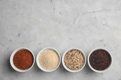 Photo of Flat lay composition with different types of quinoa and space for text on grey background