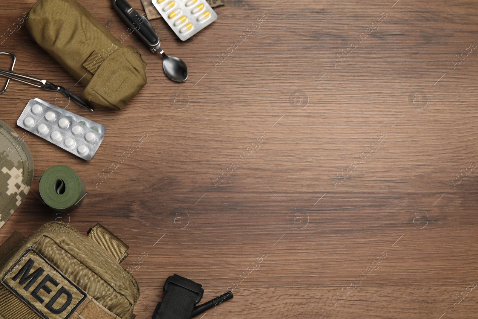 Photo of Military first aid kit on wooden table, flat lay. Space for text