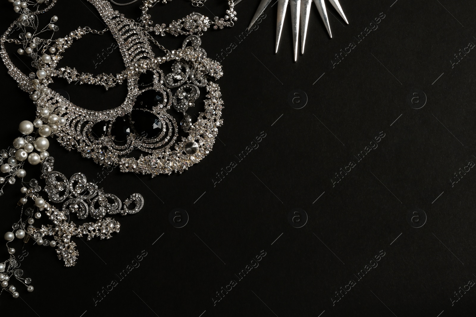 Photo of Different elegant jewelry on black background, top view. Space for text