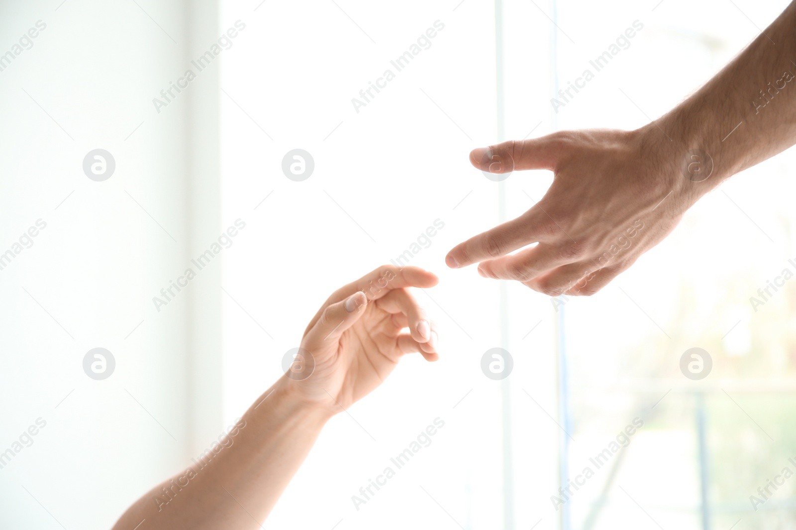 Photo of Man and woman reaching out to one another on light background. Unity concept