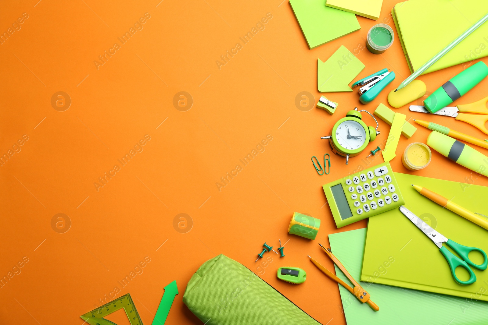 Photo of Different bright school stationery on orange background, flat lay. Space for text