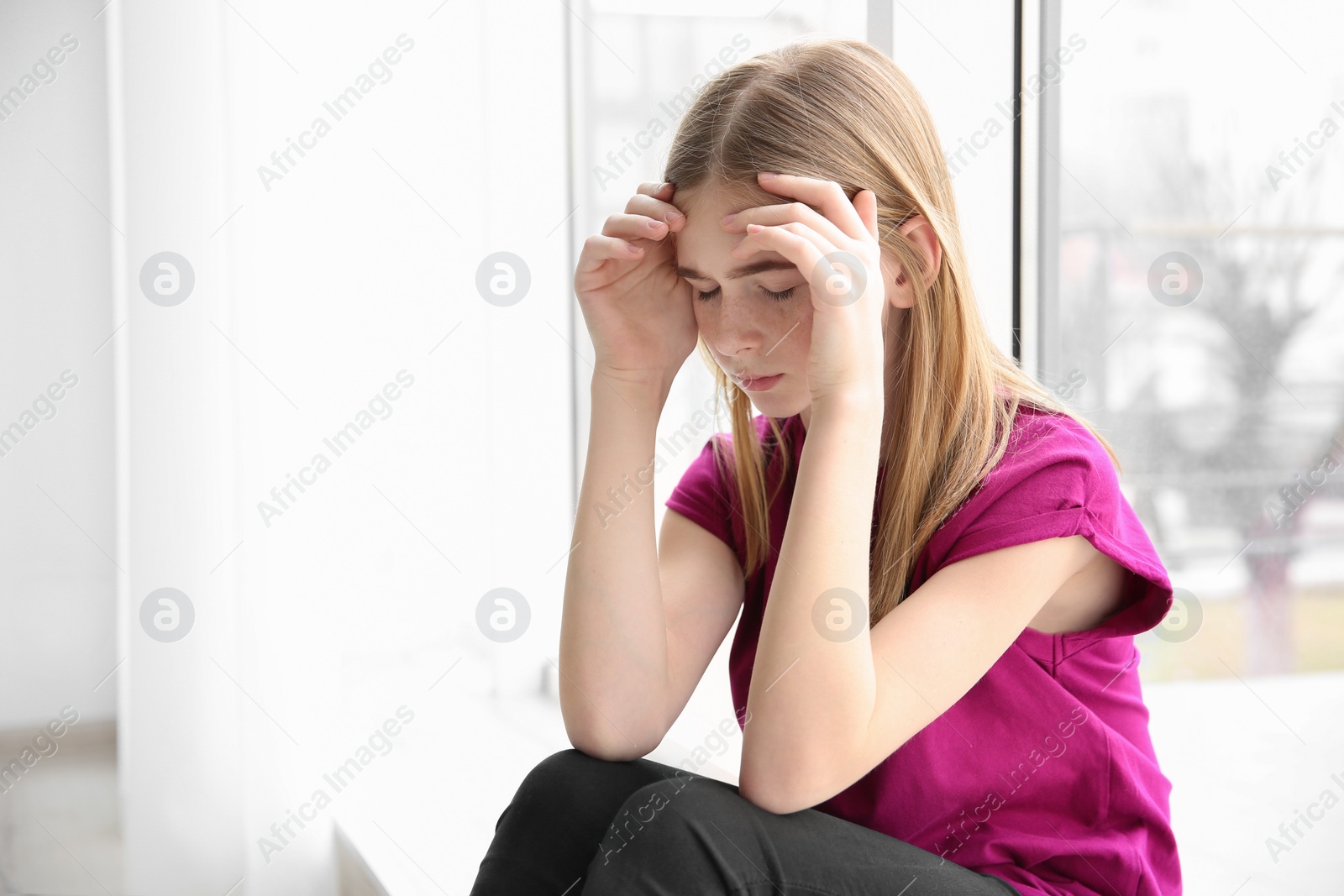 Photo of Teenage girl suffering from headache indoors