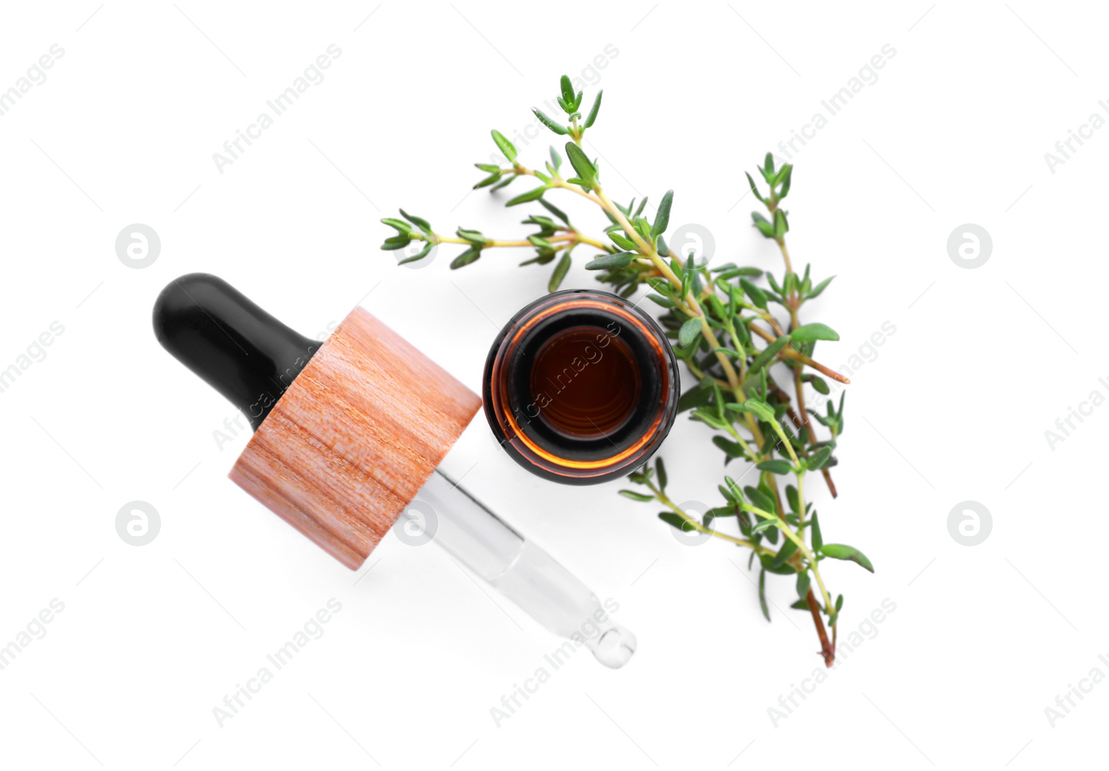 Photo of Bottle of thyme essential oil and fresh plant isolated on white, top view