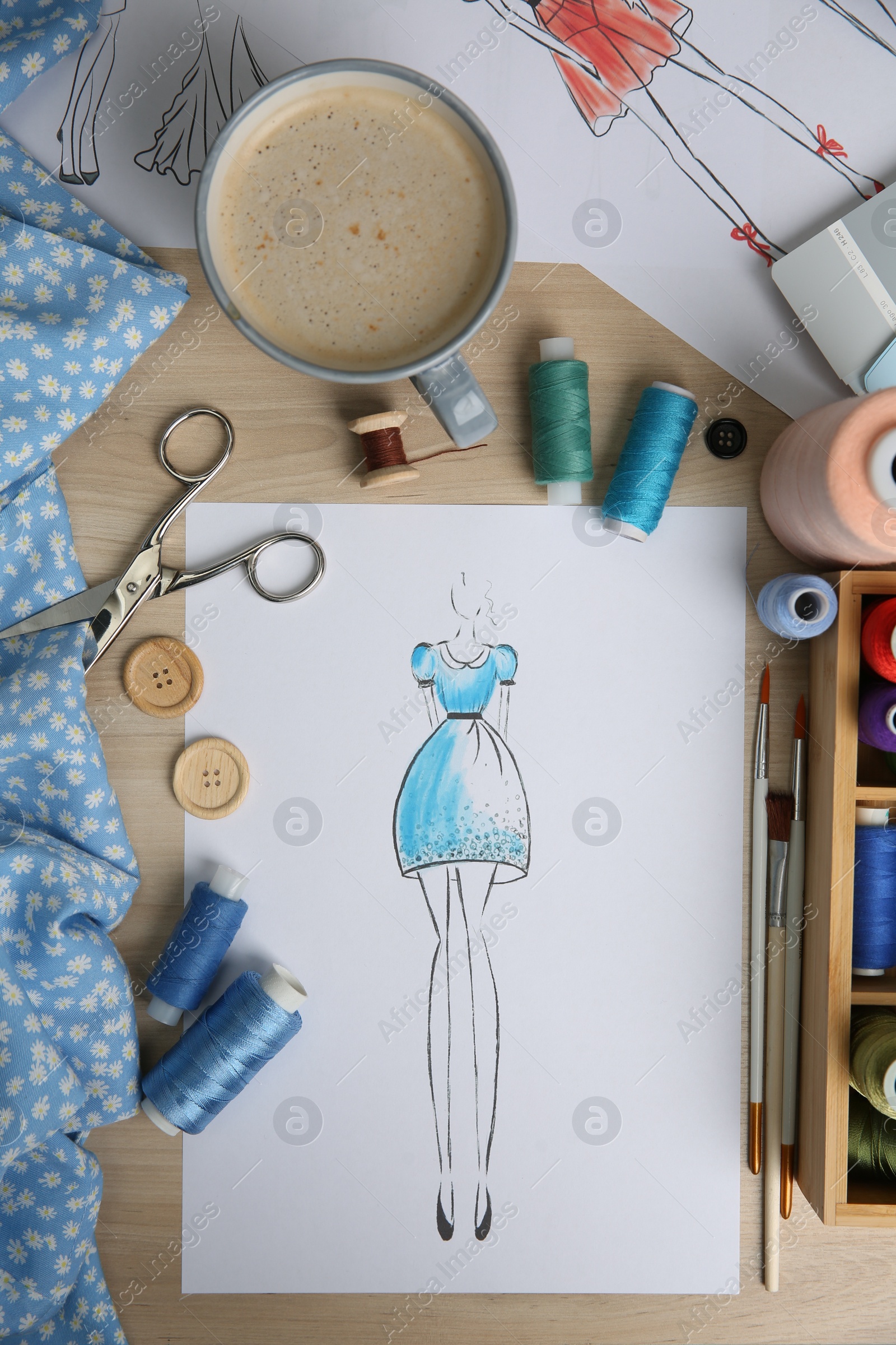 Photo of Sketch of fashion dress and thread supplies at designer's workplace, flat lay