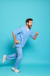 Doctor with stethoscope running on light blue background