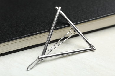 Photo of Beautiful hair clip and book on white table, closeup