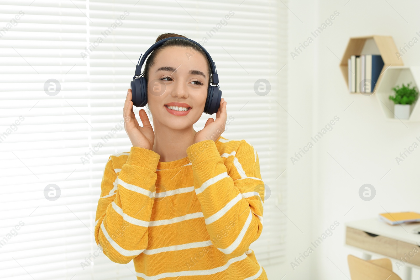 Photo of Happy woman in headphones enjoying music at home