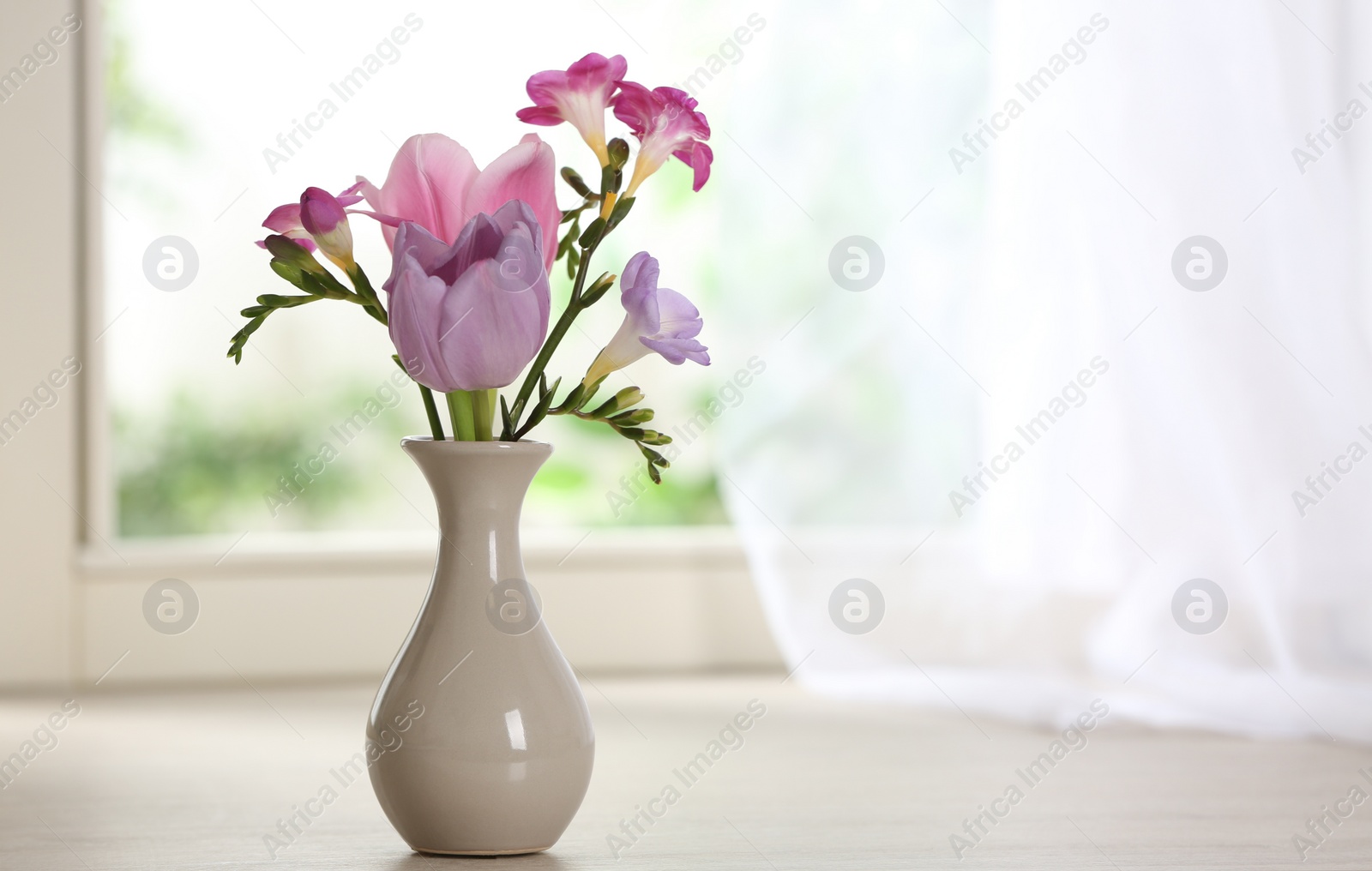 Photo of Beautiful fresh flowers on window sill indoors. Space for text