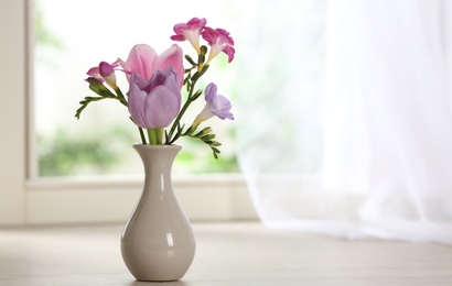 Beautiful fresh flowers on window sill indoors. Space for text