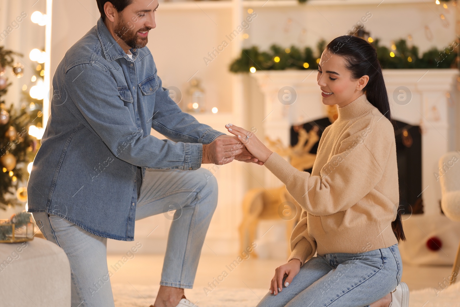 Photo of Man with engagement ring making proposal to his girlfriend at home on Christmas