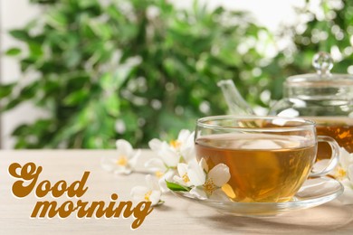 Good morning. Glass cup of aromatic jasmine tea and fresh flowers on wooden table