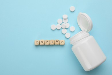 Photo of Wooden cubes with word Doping and drugs on turquoise background, flat lay