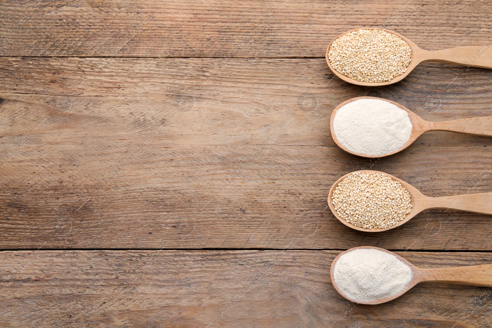 Photo of Spoons with quinoa flour and seeds on wooden table, flat lay. Space for text