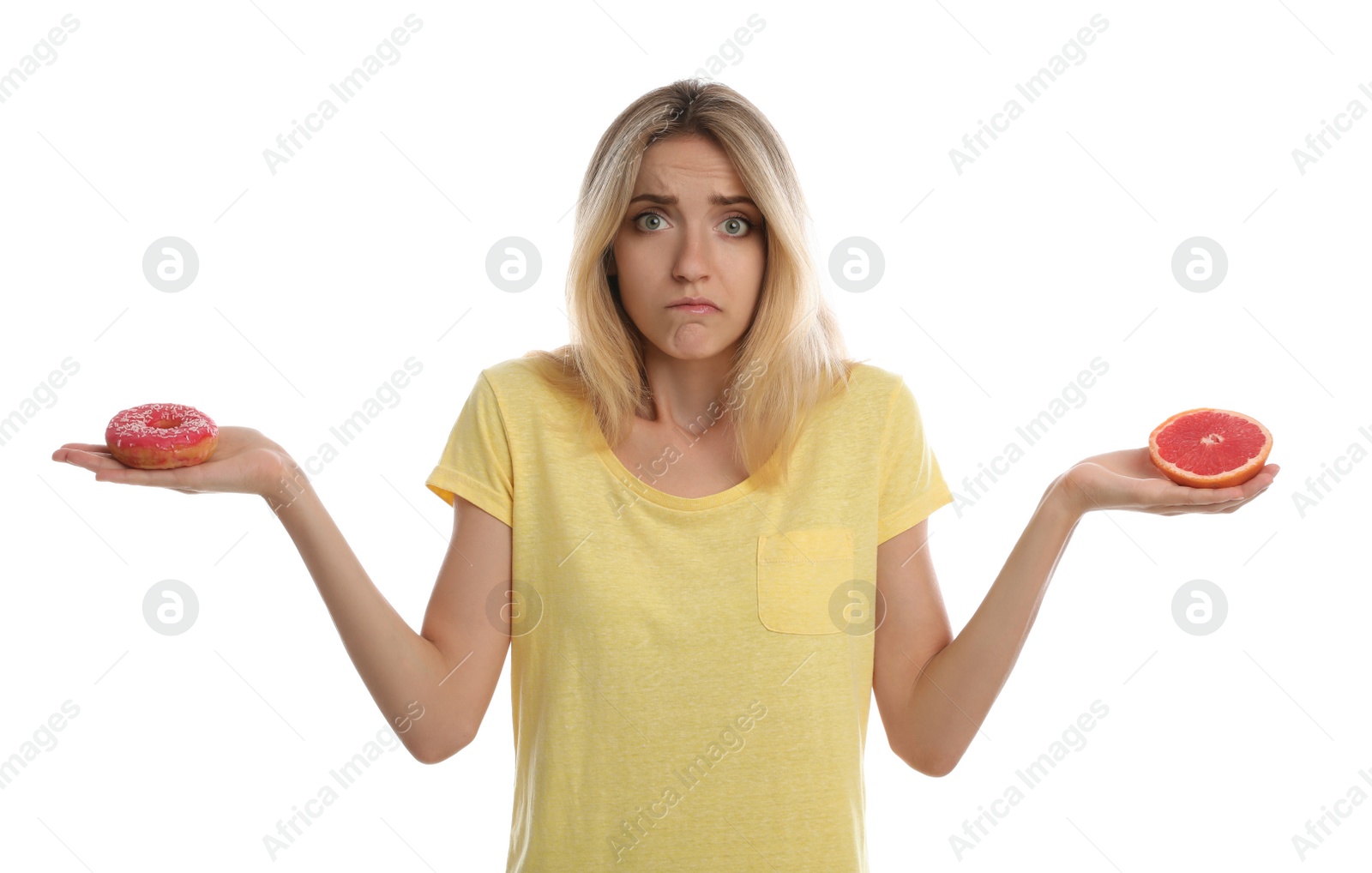 Photo of Woman choosing between doughnut and fresh grapefruit on white background