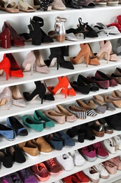 Photo of Shelving unit with different shoes. Element of dressing room interior