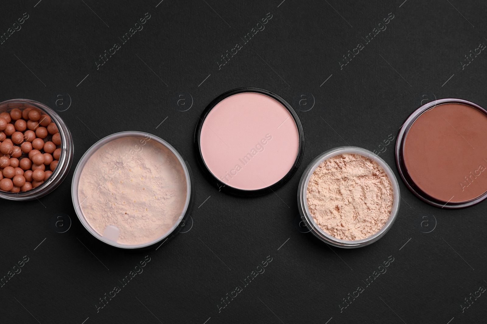 Photo of Different face powders on black background, flat lay