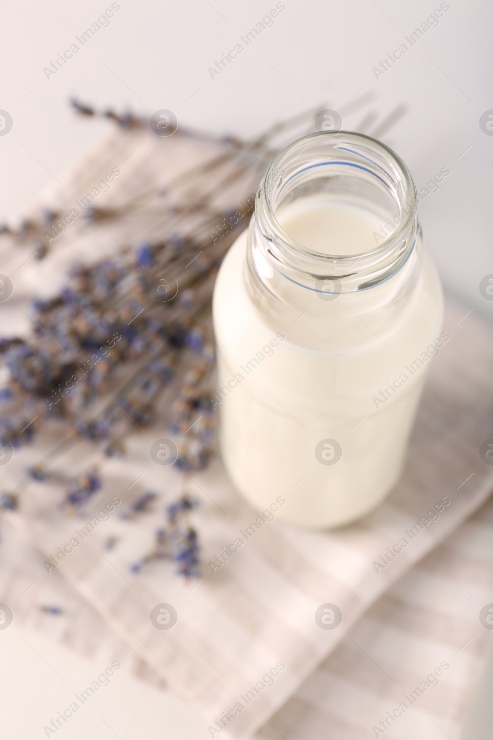 Photo of Bottle of tasty milk on light table, above view