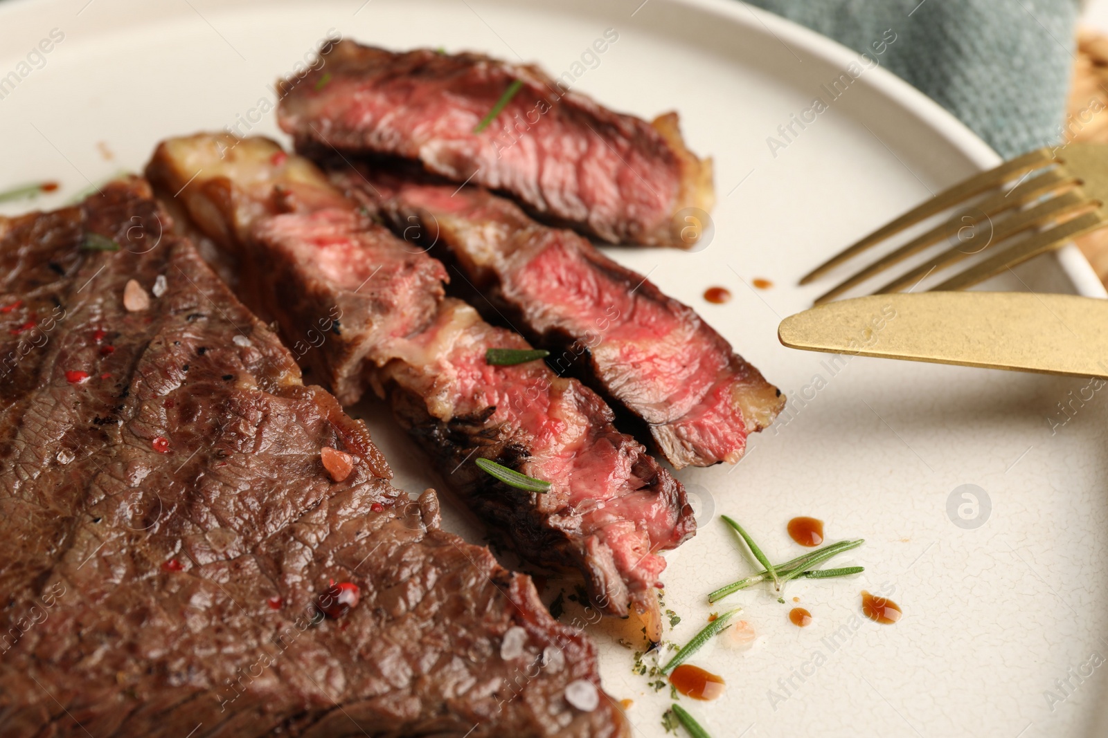 Photo of Delicious grilled beef steak with spices on plate, closeup