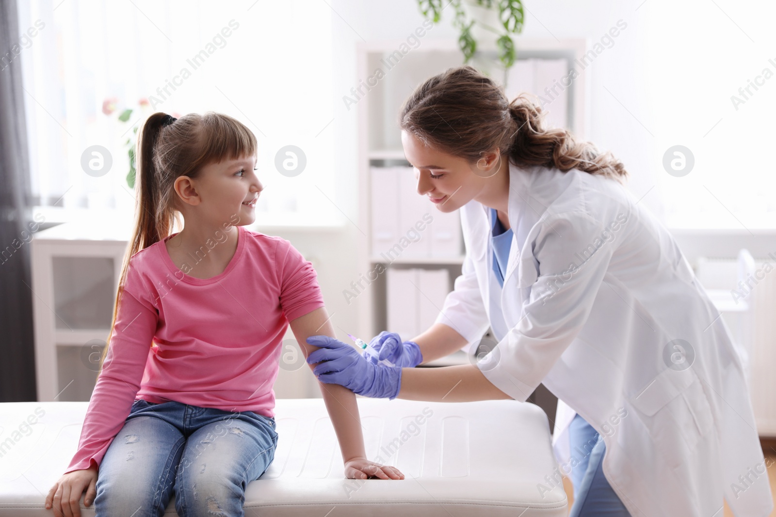 Photo of Little girl receiving chickenpox vaccination in clinic. Varicella virus prevention