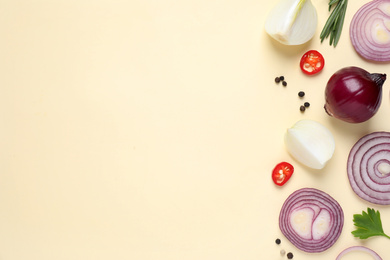 Photo of Flat lay composition with cut onion and spices on beige background. Space for text