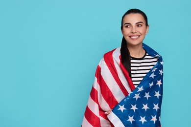 Photo of 4th of July - Independence Day of USA. Happy woman with American flag on light blue background, space for text