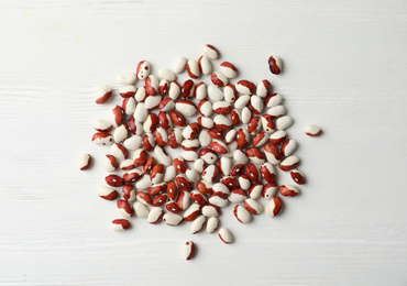 Photo of Raw beans on white wooden background, flat lay. Vegetable seeds