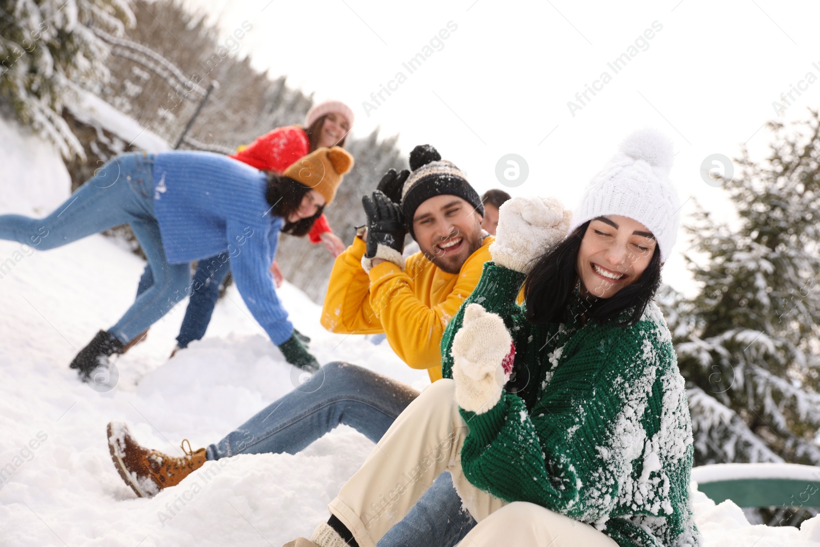 Photo of Group of friends playing snowballs outdoors. Winter vacation