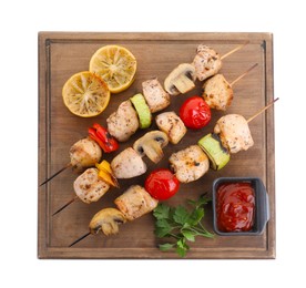 Photo of Wooden board with delicious shish kebabs, tomato sauce and grilled vegetables isolated on white, top view