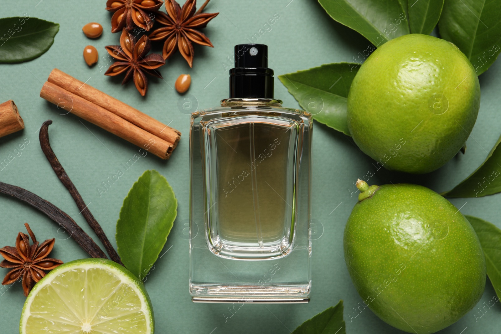 Photo of Flat lay composition with bottle of perfume and fresh citrus fruits on pale green background