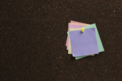 Photo of Colorful paper notes pinned to cork board. Space for text