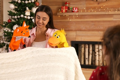 Mother performing puppet show for her daughter at home