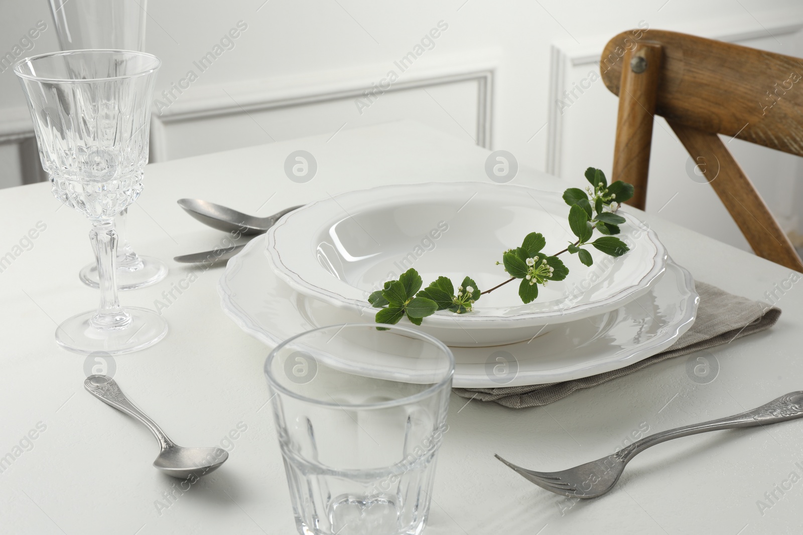 Photo of Stylish setting with cutlery and plates on white textured table