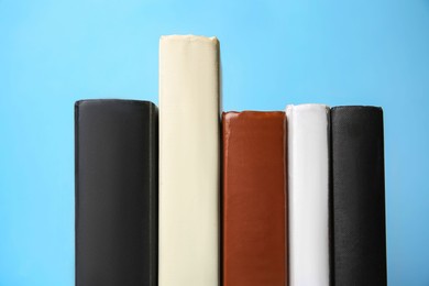 Photo of Collection of books on light blue background, closeup