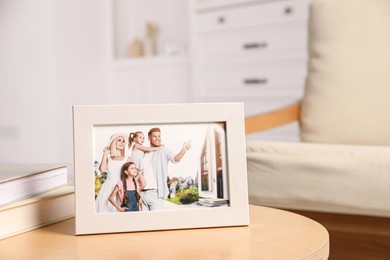 Photo of Pleasant memories. White photo frame with family portrait on wooden table indoors. Space for text