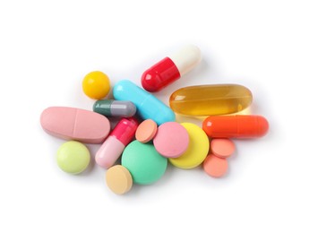 Photo of Heap of different colorful pills isolated on white, top view