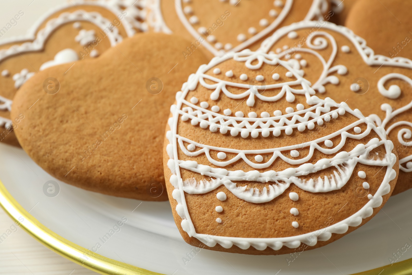 Photo of Tasty heart shaped gingerbread cookies in plate, closeup