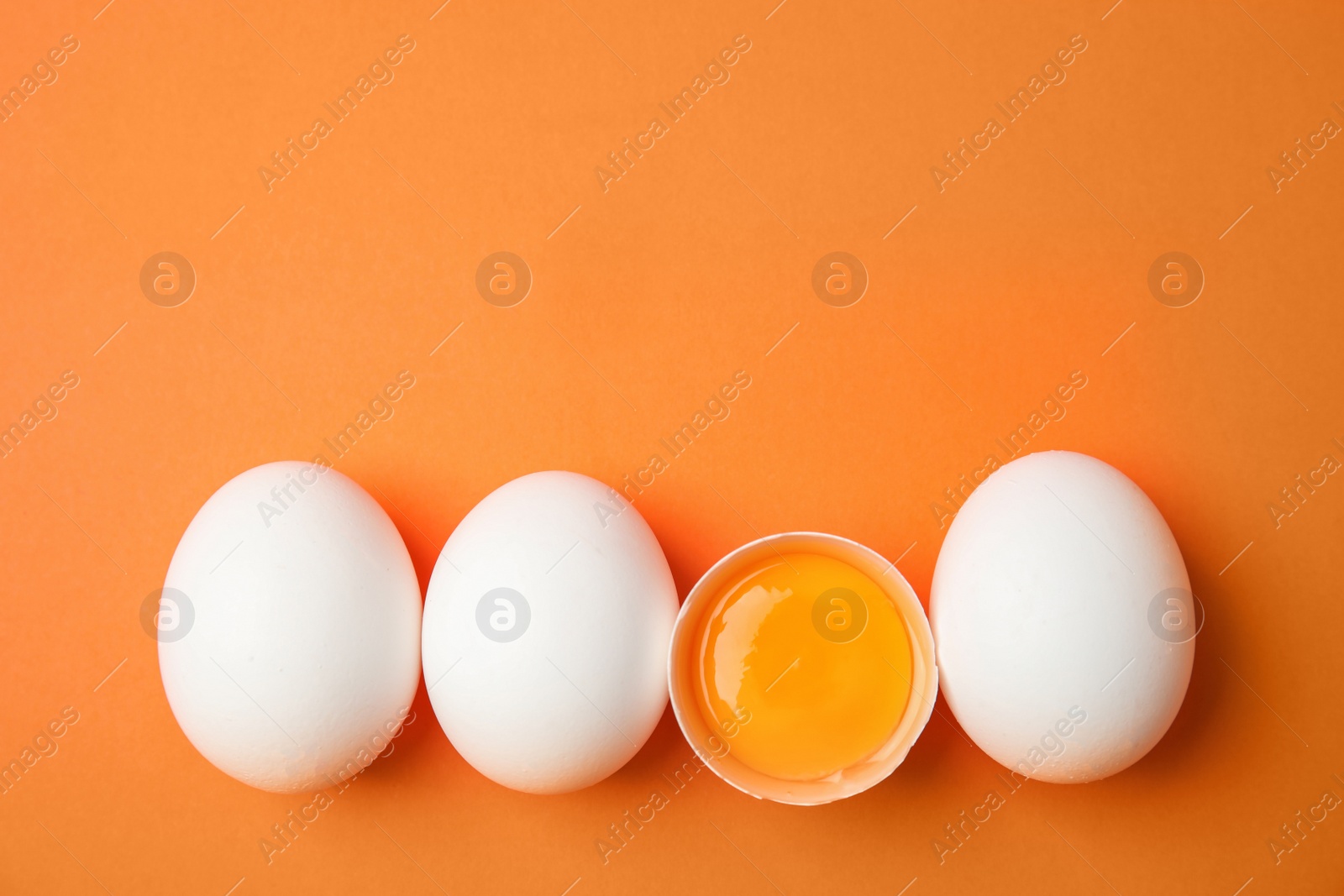 Photo of Raw chicken eggs on color background, top view. Space for text