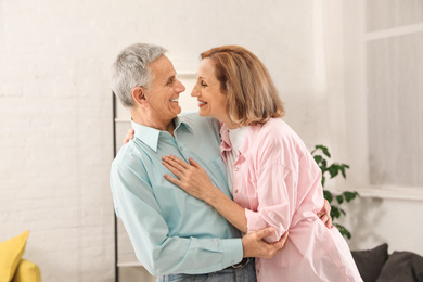 Happy senior couple dancing together at home