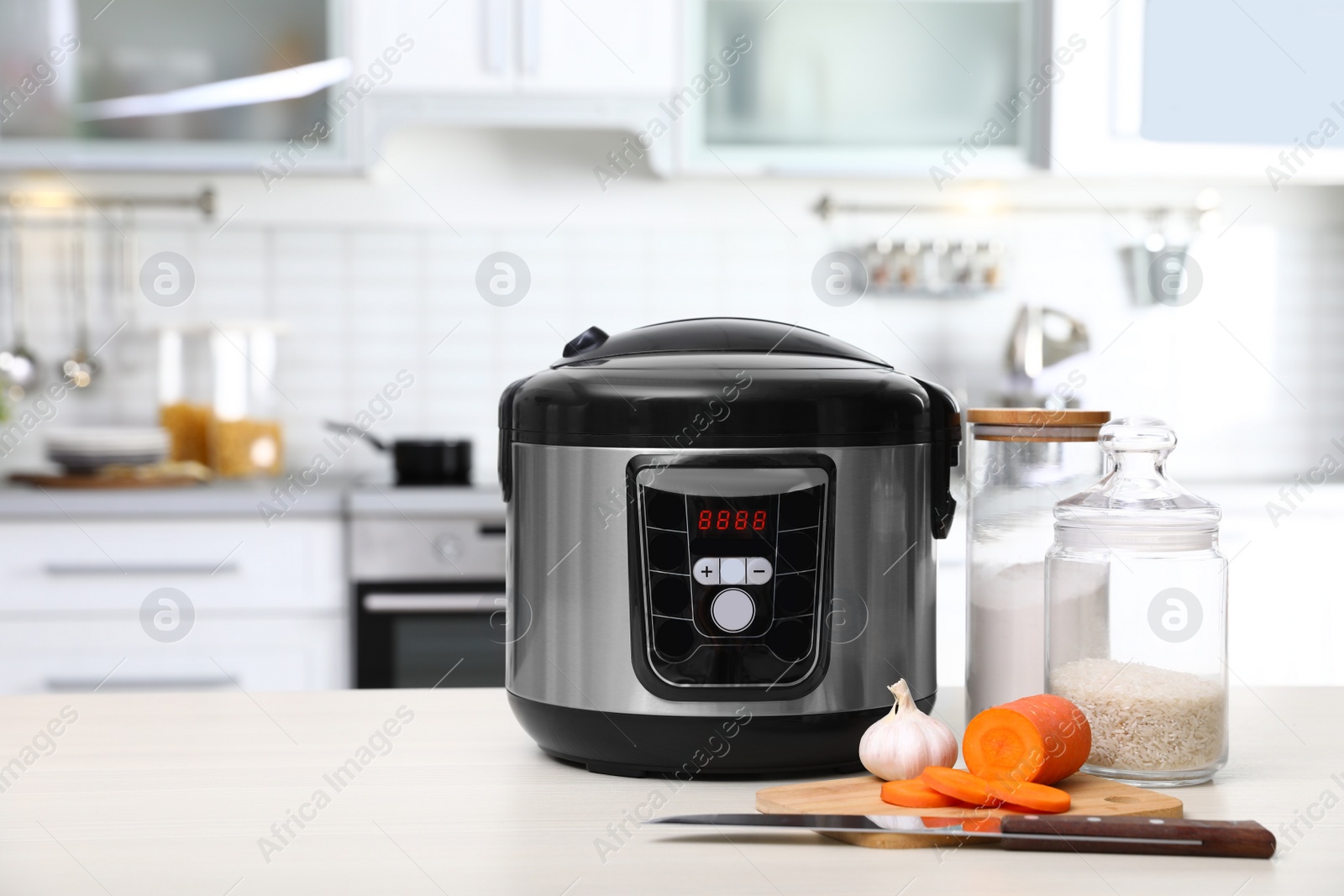 Photo of Modern multi cooker and products on table in kitchen. Space for text