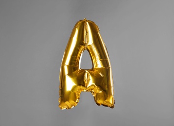 Golden letter A balloon on grey background