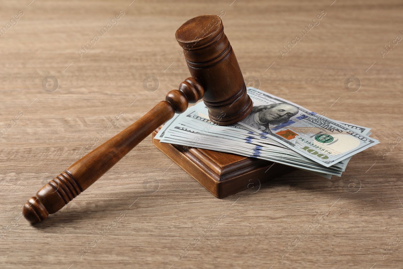 Photo of Judge's gavel and money on wooden table