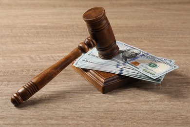 Judge's gavel and money on wooden table