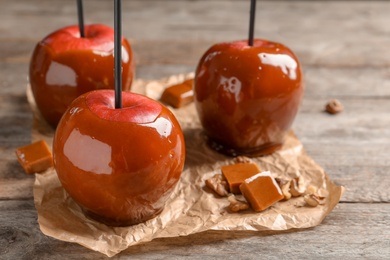 Photo of Delicious red caramel apples on table