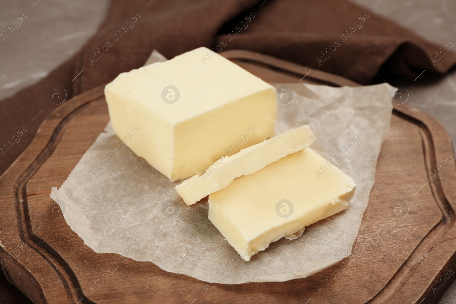 Photo of Wooden board with tasty fresh butter, closeup