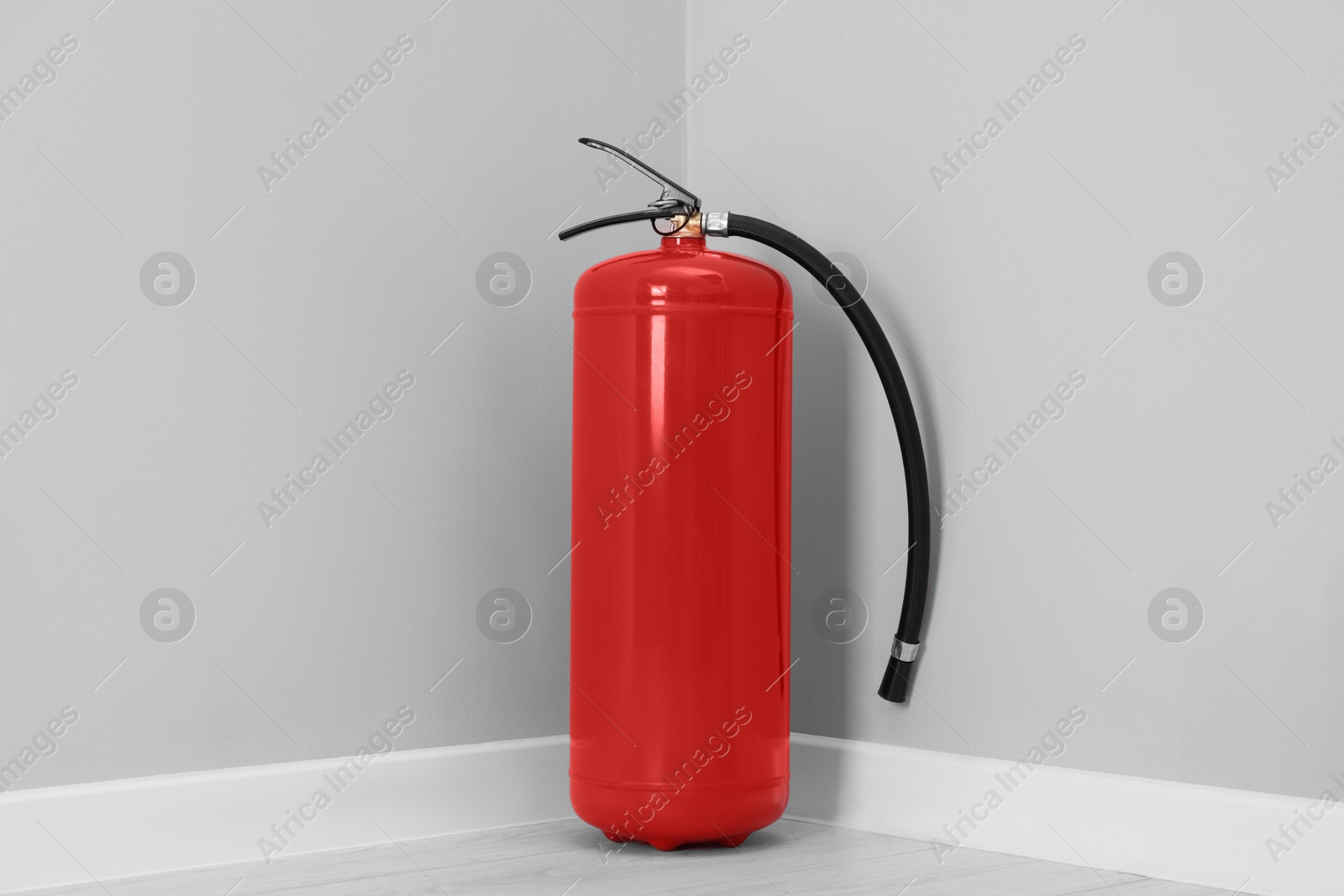 Photo of Red fire extinguisher on floor in corner